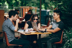 3 people working at a public table